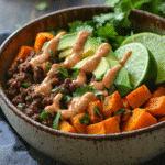 Ground Beef Sweet Potato Bowl: Quick, Healthy Comfort Food 2 Assembled ground beef sweet potato bowl with toppings and sauce