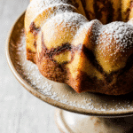 Cinnamon Swirl Bundt Cake – A Cozy Dessert Delight! 5 close up of a freshly baked cinnamon swirl bundt cake on a rustic ceramic cake stand golden crust w koj9duz7lidvndkzy38q 1
