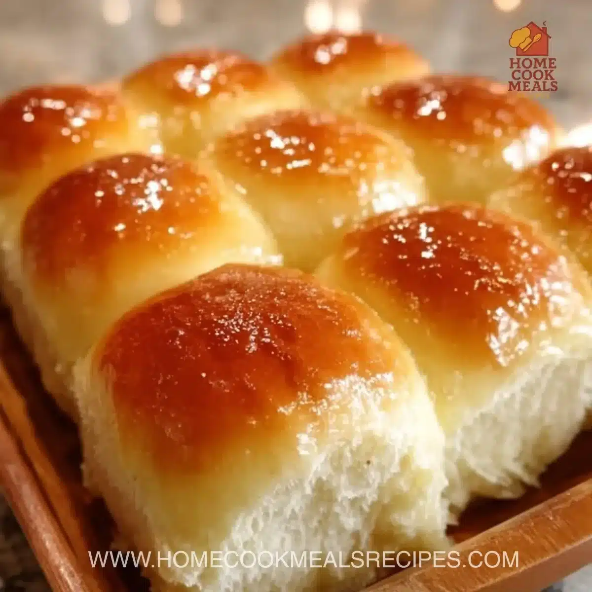 Freshly baked soft and buttery dinner rolls on a wooden table