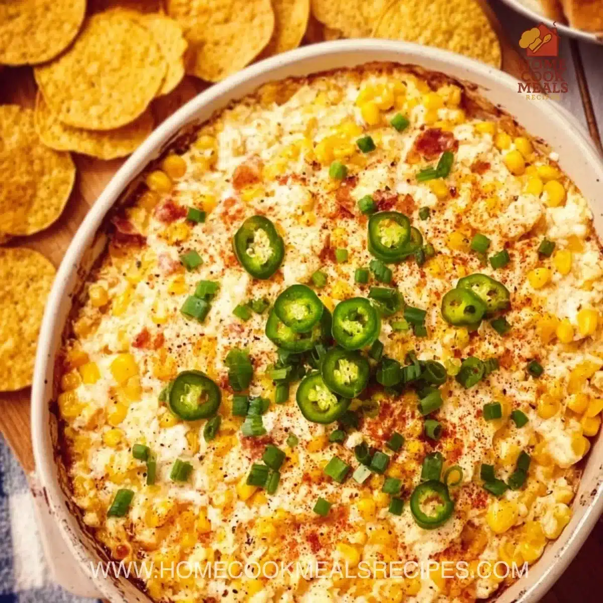 Creamy Crack Corn Dip served with tortilla chips and garnished with herbs