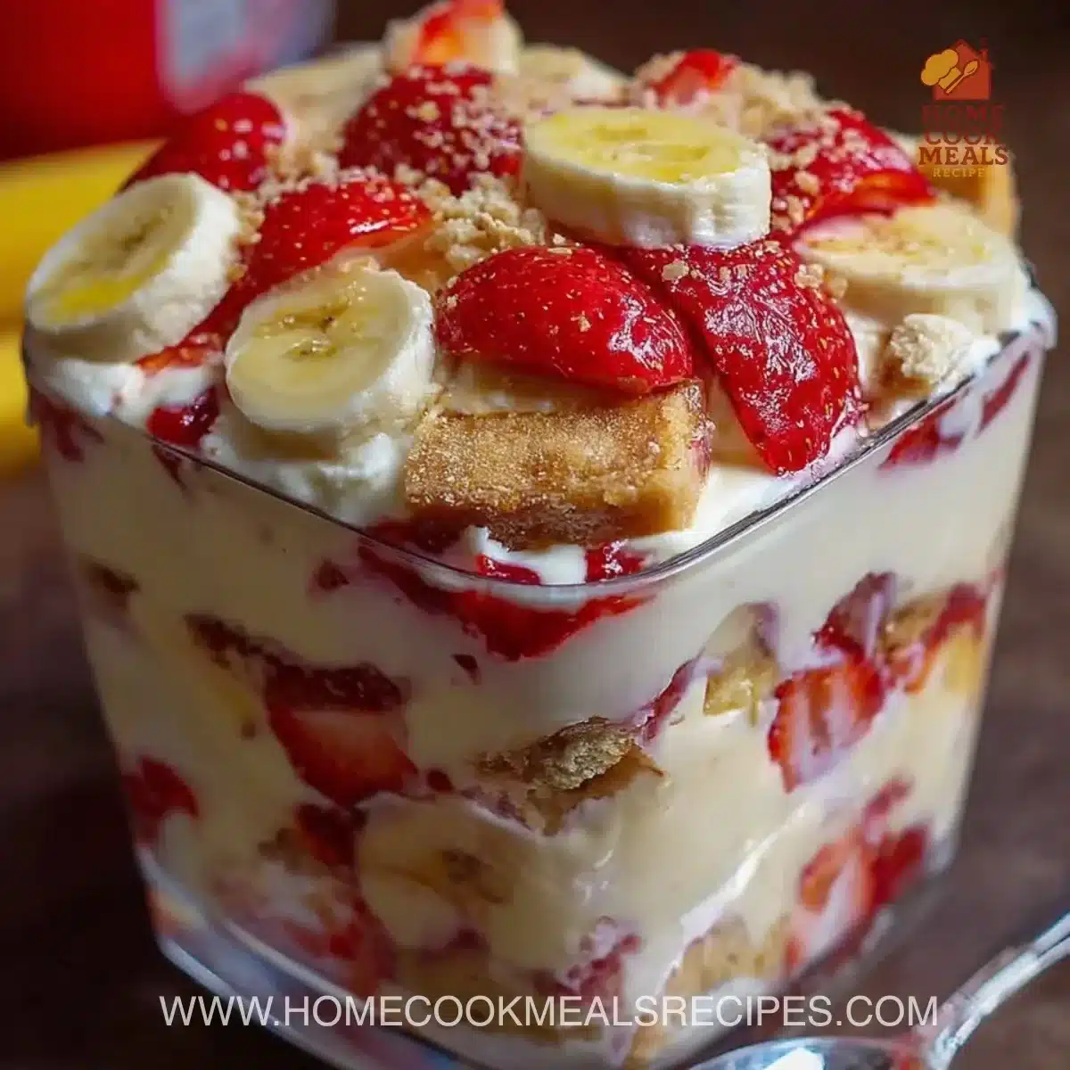 Strawberry banana pudding dessert in a glass with fresh strawberries