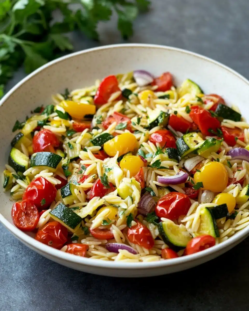 Bowl of roasted vegetable orzo with colorful veggies and herbs