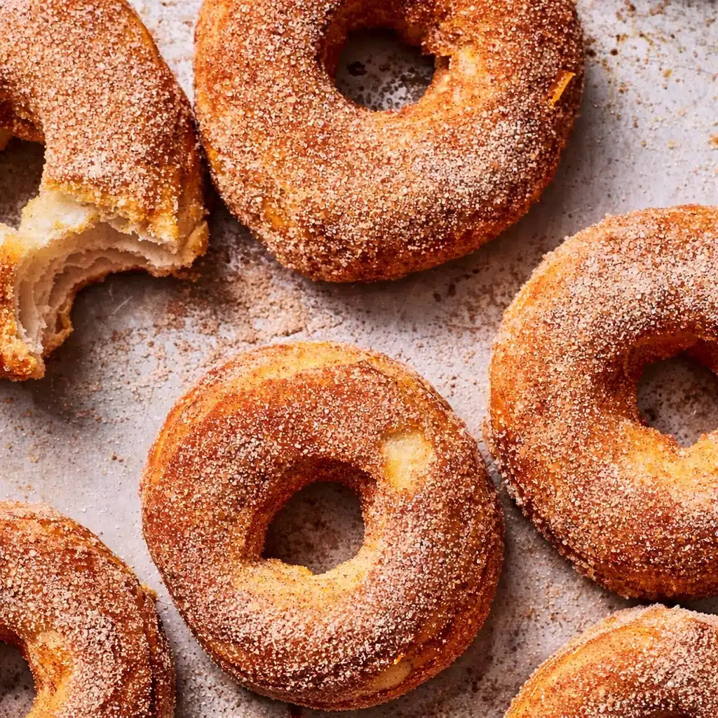 Golden brown air fryer donuts topped with cinnamon sugar and glaze
