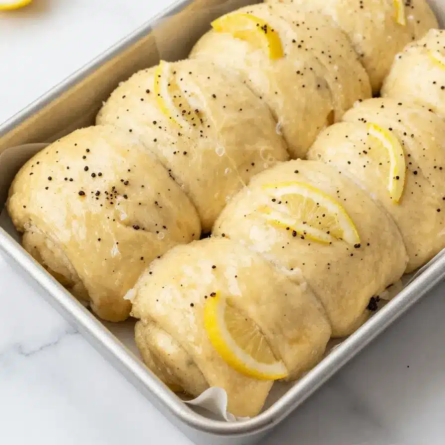 Lemon Rolls - Delicious Recipe Ready in 90 Minutes 2 Freshly baked lemon rolls served on a white plate with a drizzle of icing.