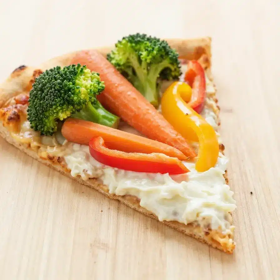 A colorful cold veggie pizza served on a wooden platter, perfect for Labor Day celebrations.